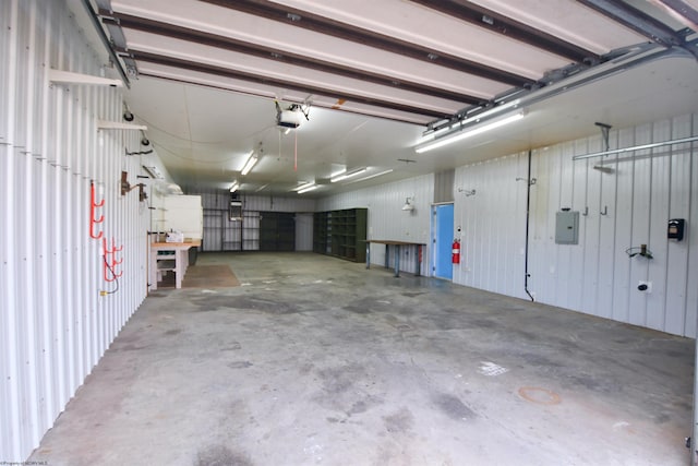 garage with electric panel, wood walls, and a garage door opener