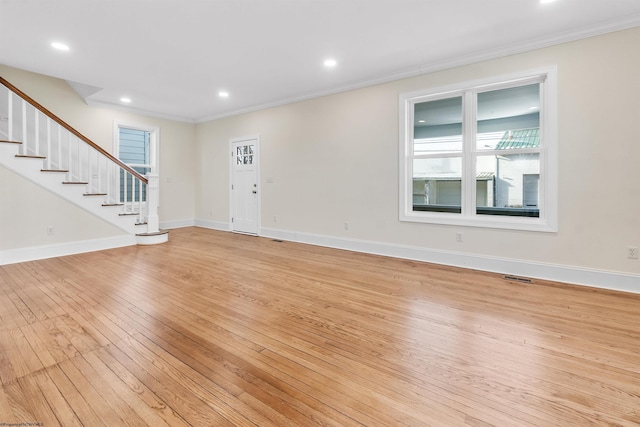 interior space featuring a healthy amount of sunlight, light wood-type flooring, and crown molding