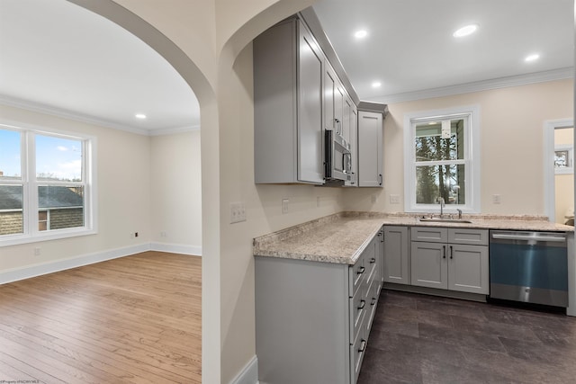 kitchen with gray cabinetry, a wealth of natural light, sink, stainless steel appliances, and light stone counters