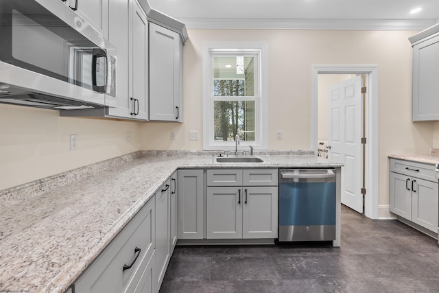 kitchen with light stone counters, gray cabinetry, stainless steel appliances, crown molding, and sink