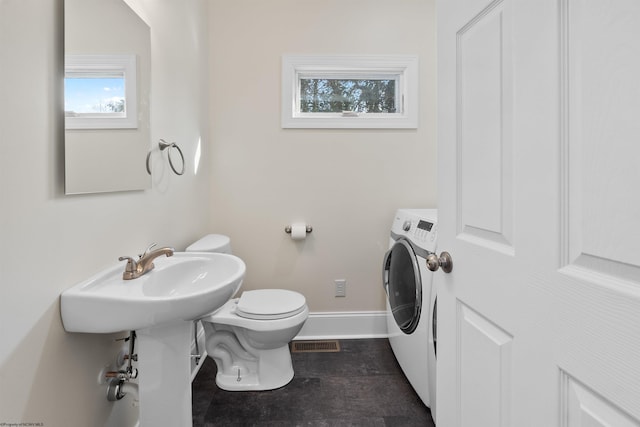 bathroom with toilet and washer / dryer