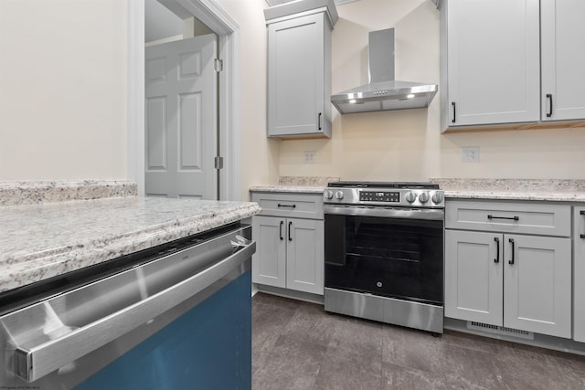 kitchen featuring gray cabinetry, light stone countertops, wall chimney range hood, and appliances with stainless steel finishes