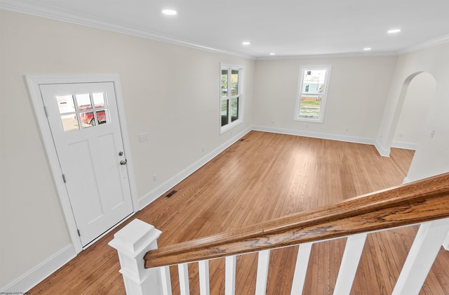 foyer entrance with light hardwood / wood-style floors and ornamental molding