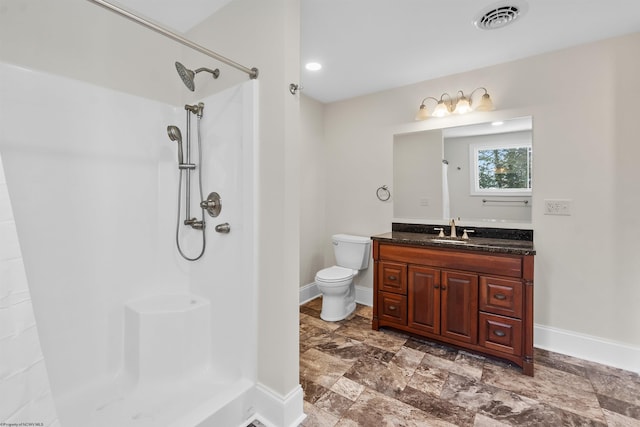 bathroom with vanity, toilet, and a shower