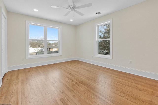 empty room with light wood-type flooring, ceiling fan, and a healthy amount of sunlight