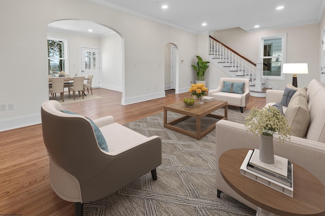 living room with light wood-type flooring and ornamental molding