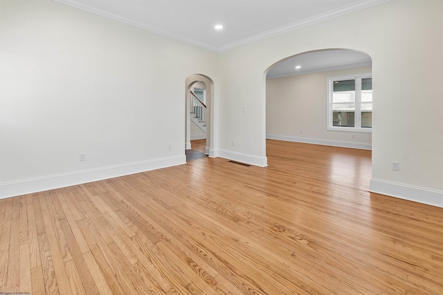 spare room featuring light wood-type flooring and ornamental molding