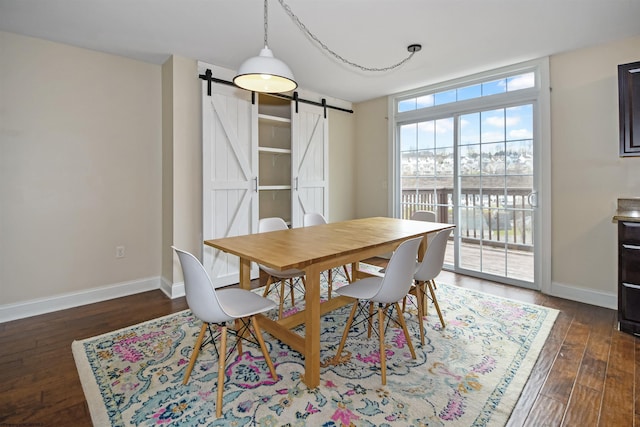 dining area with dark hardwood / wood-style floors and a barn door