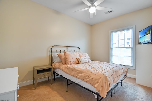 bedroom featuring ceiling fan, light colored carpet, and multiple windows