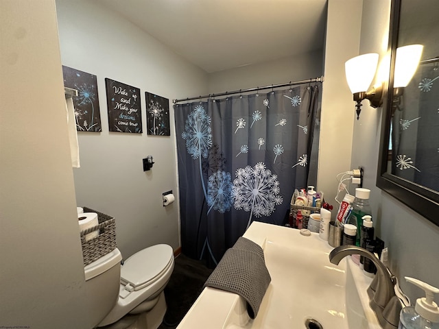 bathroom featuring a shower with curtain and toilet