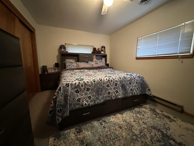 bedroom with baseboard heating, ceiling fan, and fridge