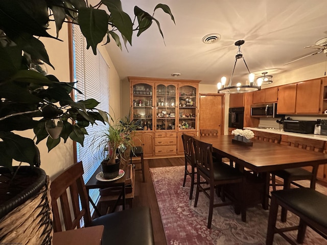 dining space featuring dark hardwood / wood-style floors and an inviting chandelier