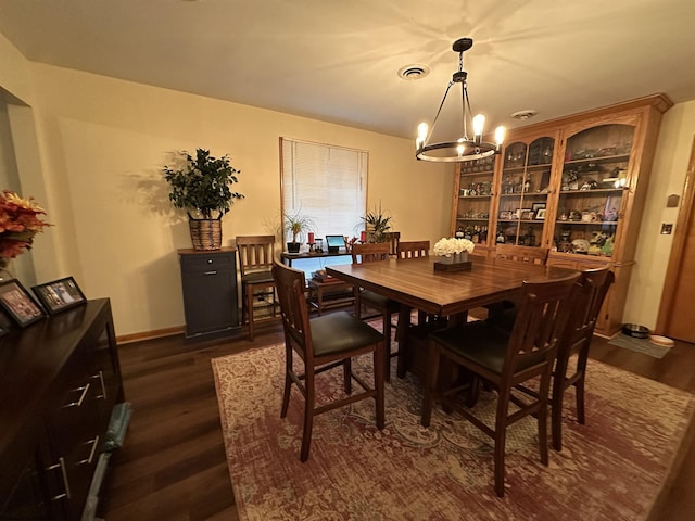 dining area featuring dark hardwood / wood-style floors and a notable chandelier