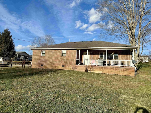 rear view of property featuring a lawn