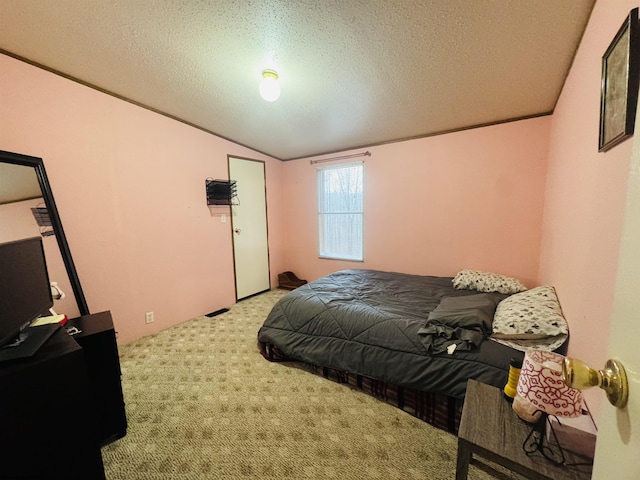 carpeted bedroom featuring a textured ceiling and vaulted ceiling