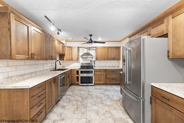 kitchen with ornamental molding, stainless steel appliances, ceiling fan, wall chimney range hood, and sink