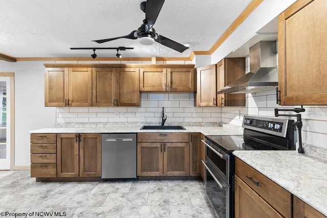 kitchen featuring appliances with stainless steel finishes, tasteful backsplash, wall chimney exhaust hood, ceiling fan, and sink