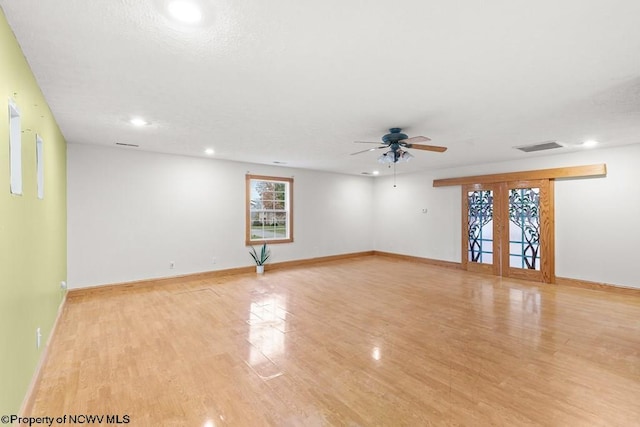 unfurnished room with ceiling fan, french doors, and light hardwood / wood-style flooring