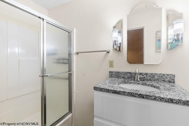 bathroom featuring vanity and bath / shower combo with glass door