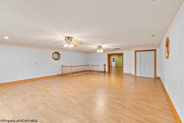 empty room with ceiling fan, light hardwood / wood-style floors, and crown molding