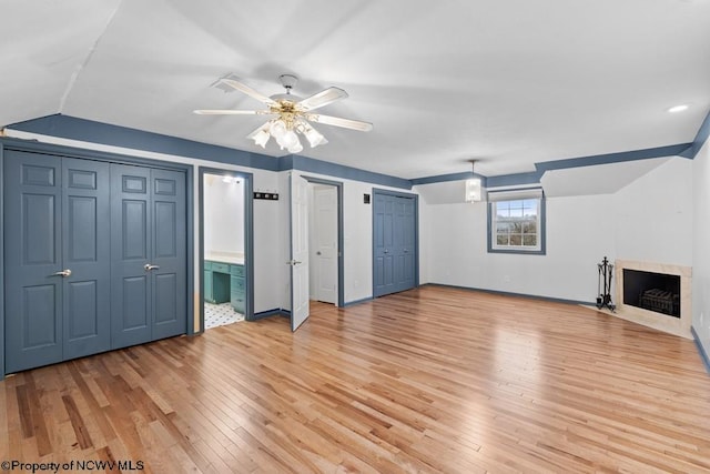 interior space with ceiling fan, light wood-type flooring, and vaulted ceiling