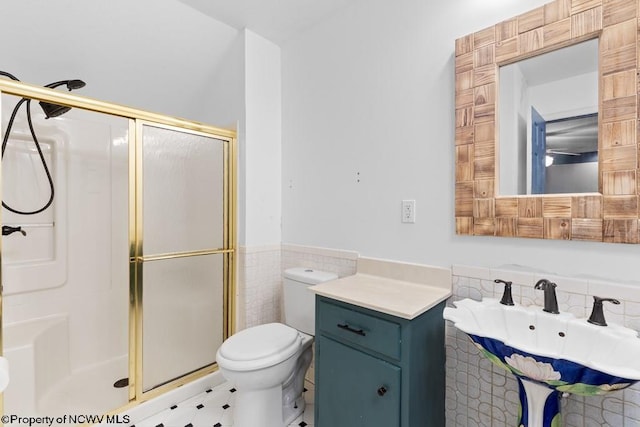 bathroom with walk in shower, toilet, tile walls, and sink