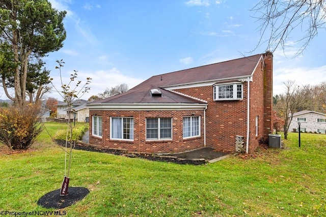 back of house featuring a yard and central air condition unit