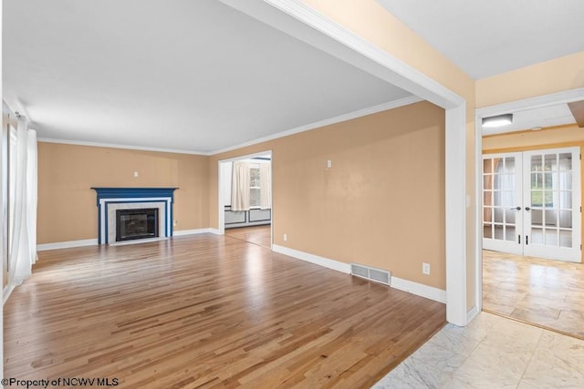 unfurnished living room featuring french doors, light wood-type flooring, a baseboard radiator, and ornamental molding