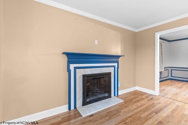 unfurnished living room featuring wood-type flooring and ornamental molding