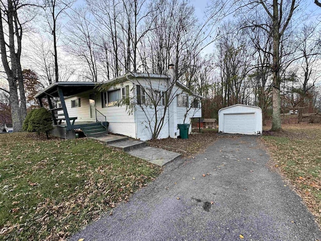 view of front of property featuring a front yard, an outdoor structure, and a garage