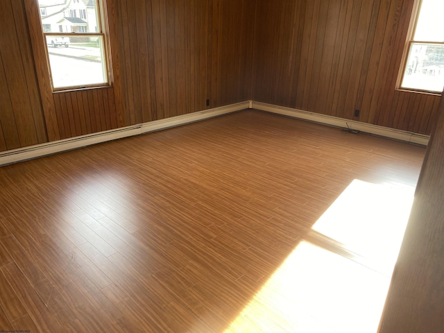 spare room featuring hardwood / wood-style floors and wood walls