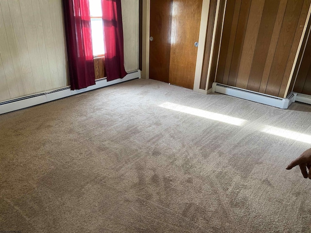 carpeted empty room with a baseboard radiator