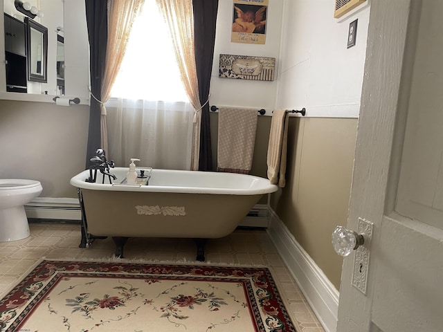 bathroom featuring a baseboard radiator, toilet, and a bathing tub