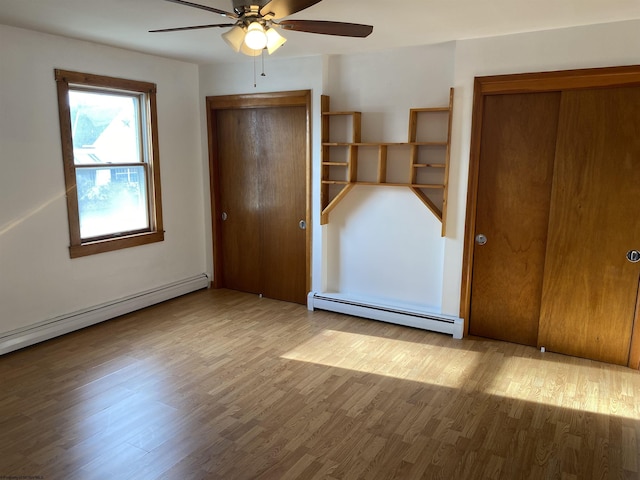 unfurnished bedroom with ceiling fan, light hardwood / wood-style flooring, and a baseboard heating unit