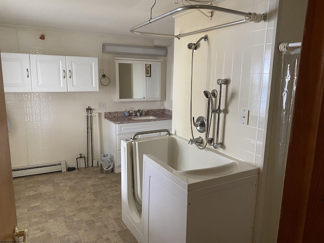 clothes washing area featuring sink and a baseboard radiator