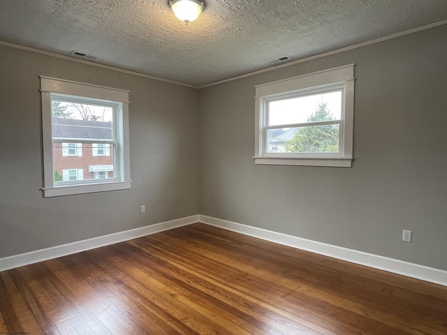 empty room featuring hardwood / wood-style floors, ornamental molding, and a textured ceiling