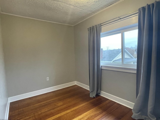 spare room featuring a textured ceiling, hardwood / wood-style flooring, and ornamental molding