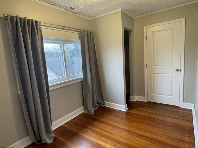 unfurnished room featuring crown molding, wood-type flooring, and a textured ceiling