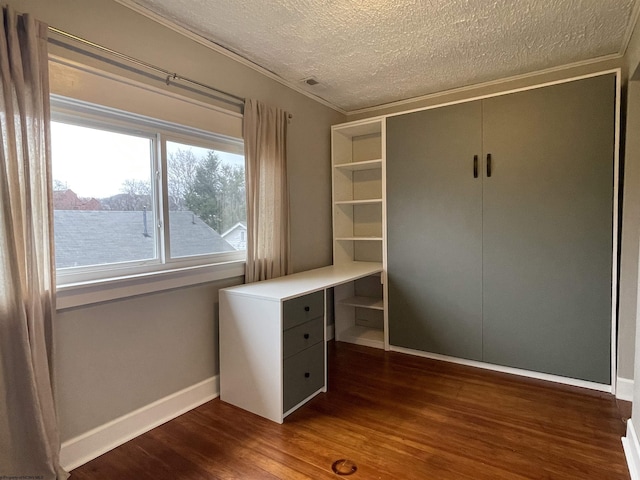 unfurnished office with dark hardwood / wood-style flooring, ornamental molding, and a textured ceiling