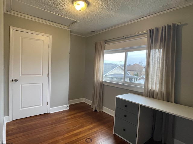 interior space with a textured ceiling, dark hardwood / wood-style flooring, and ornamental molding