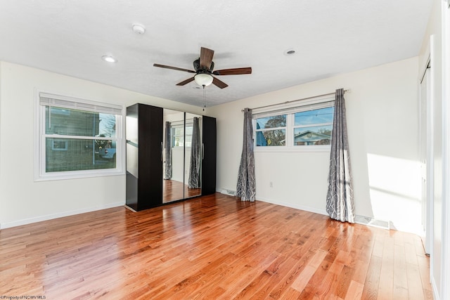 empty room with ceiling fan and light wood-type flooring