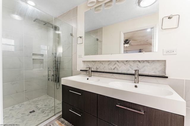 bathroom featuring vanity, backsplash, a shower with door, and ceiling fan