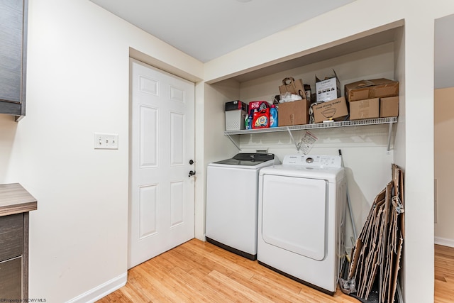 laundry room with light hardwood / wood-style flooring and washing machine and clothes dryer