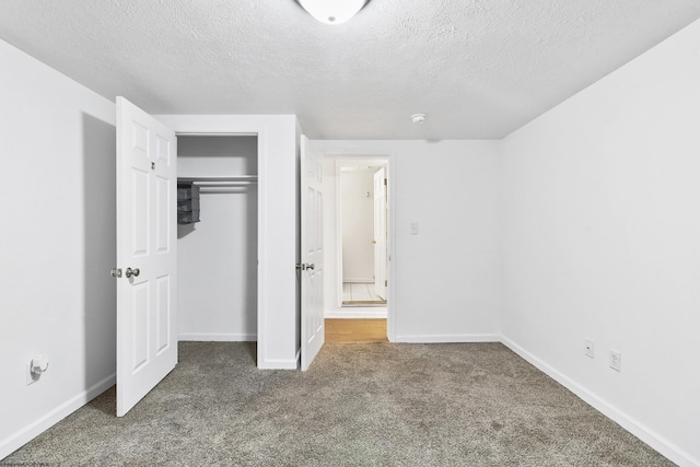 unfurnished bedroom with carpet, a textured ceiling, and a closet