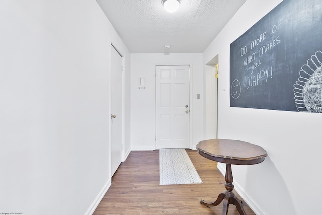 hallway featuring a textured ceiling and hardwood / wood-style flooring