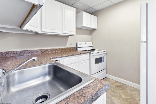 kitchen featuring white appliances, white cabinetry, a drop ceiling, and sink