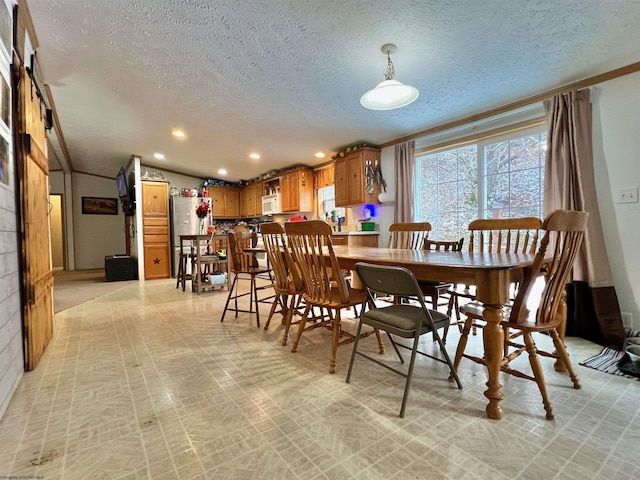 dining area with a textured ceiling and ornamental molding