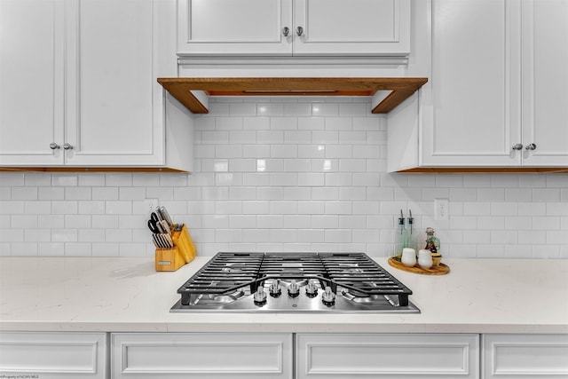 kitchen featuring decorative backsplash, white cabinetry, and stainless steel gas cooktop