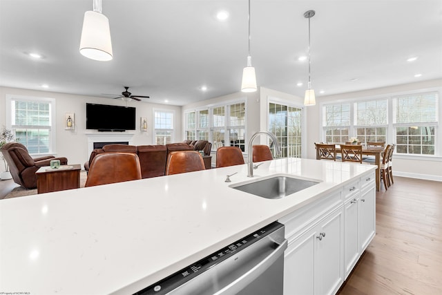 kitchen with white cabinetry, sink, ceiling fan, and pendant lighting