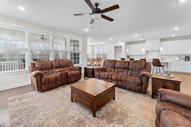 living room with ceiling fan and light wood-type flooring